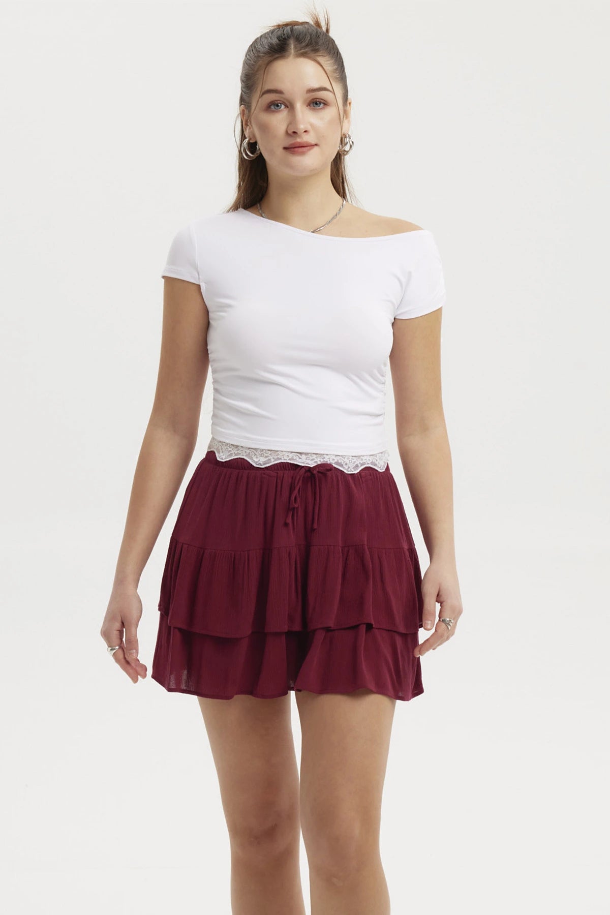 Polera asimétrica blanca con detalle de encaje en el bajo ajustada al cuerpo lisa y sin estampado