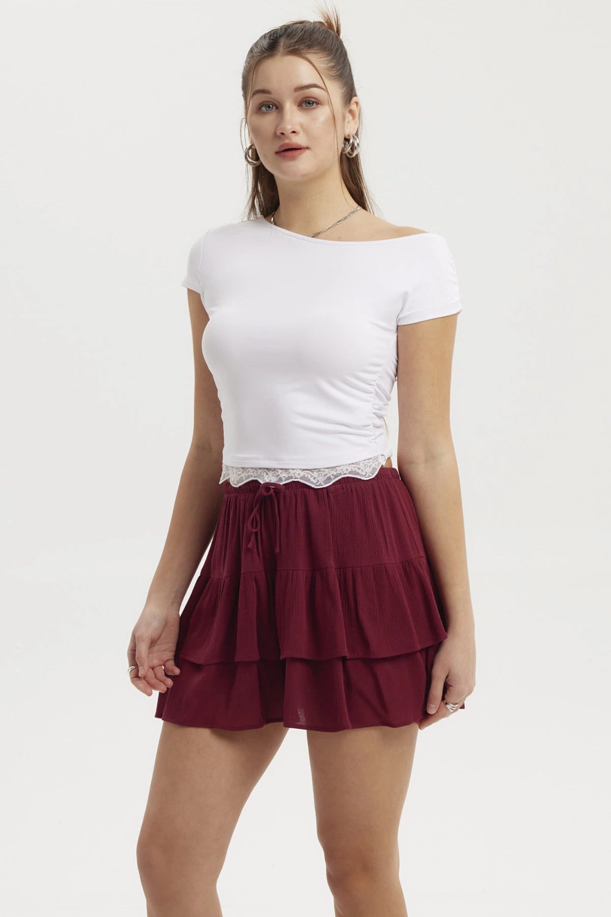 Polera asimétrica blanca con detalle de encaje en el bajo ajustada al cuerpo lisa y sin estampado