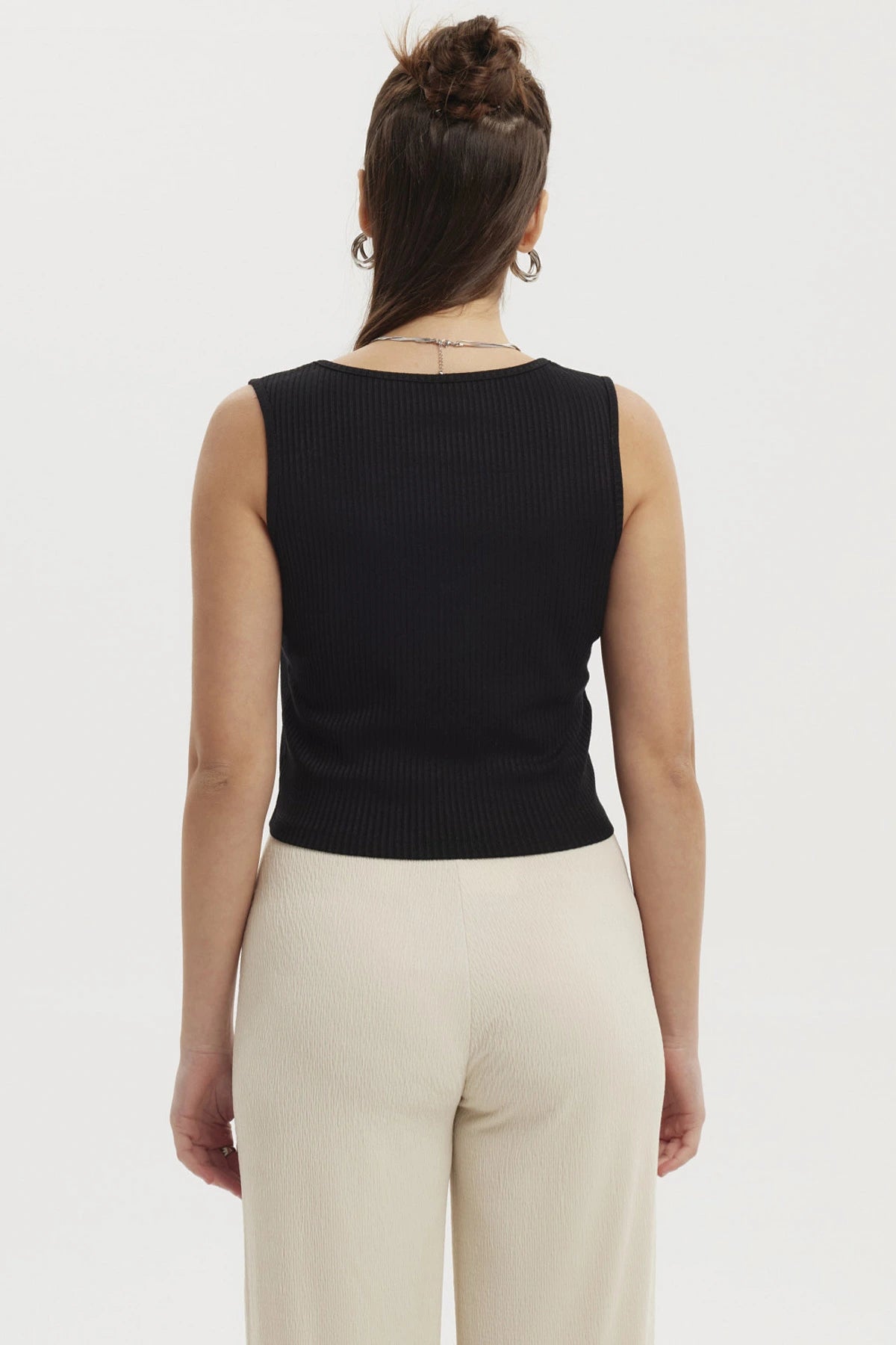 Polera sin mangas negra con lazo en el escote detalle sutil y femenino prenda lisa y versátil para cualquier ocasión