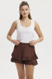 Polera blanca de mujer con lazo pequeño en el escote prenda sin mangas y diseño liso ideal para días cálidos