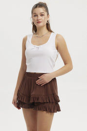 Polera blanca de mujer con lazo pequeño en el escote prenda sin mangas y diseño liso ideal para días cálidos