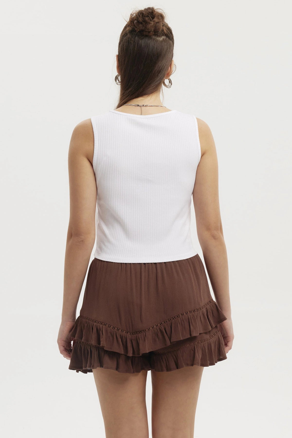 Polera blanca de mujer con lazo pequeño en el escote prenda sin mangas y diseño liso ideal para días cálidos