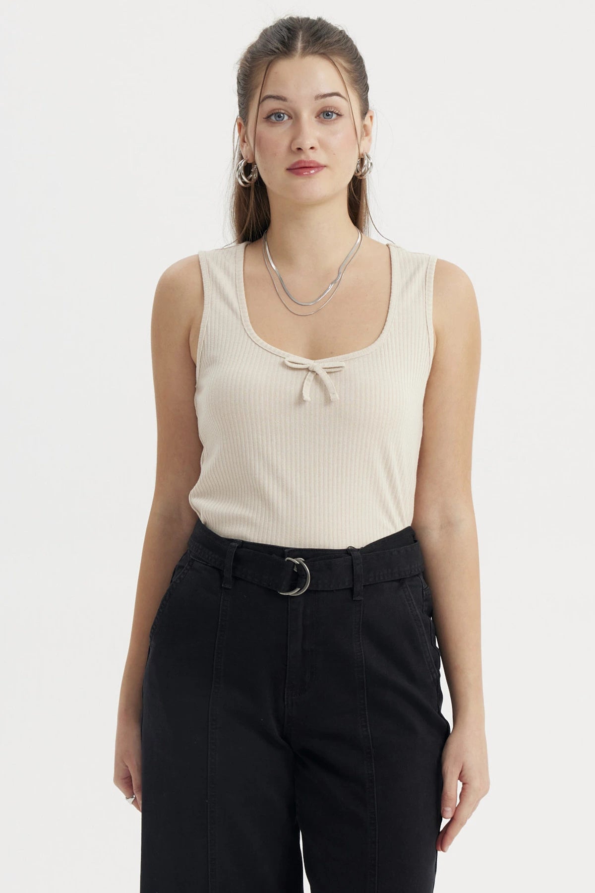Polera sin mangas beige con lazo pequeño en el escote diseño liso ideal para un look casual y fresco