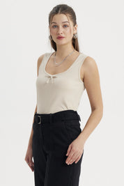 Polera sin mangas beige con lazo pequeño en el escote diseño liso ideal para un look casual y fresco