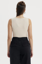 Polera sin mangas beige con lazo pequeño en el escote diseño liso ideal para un look casual y fresco
