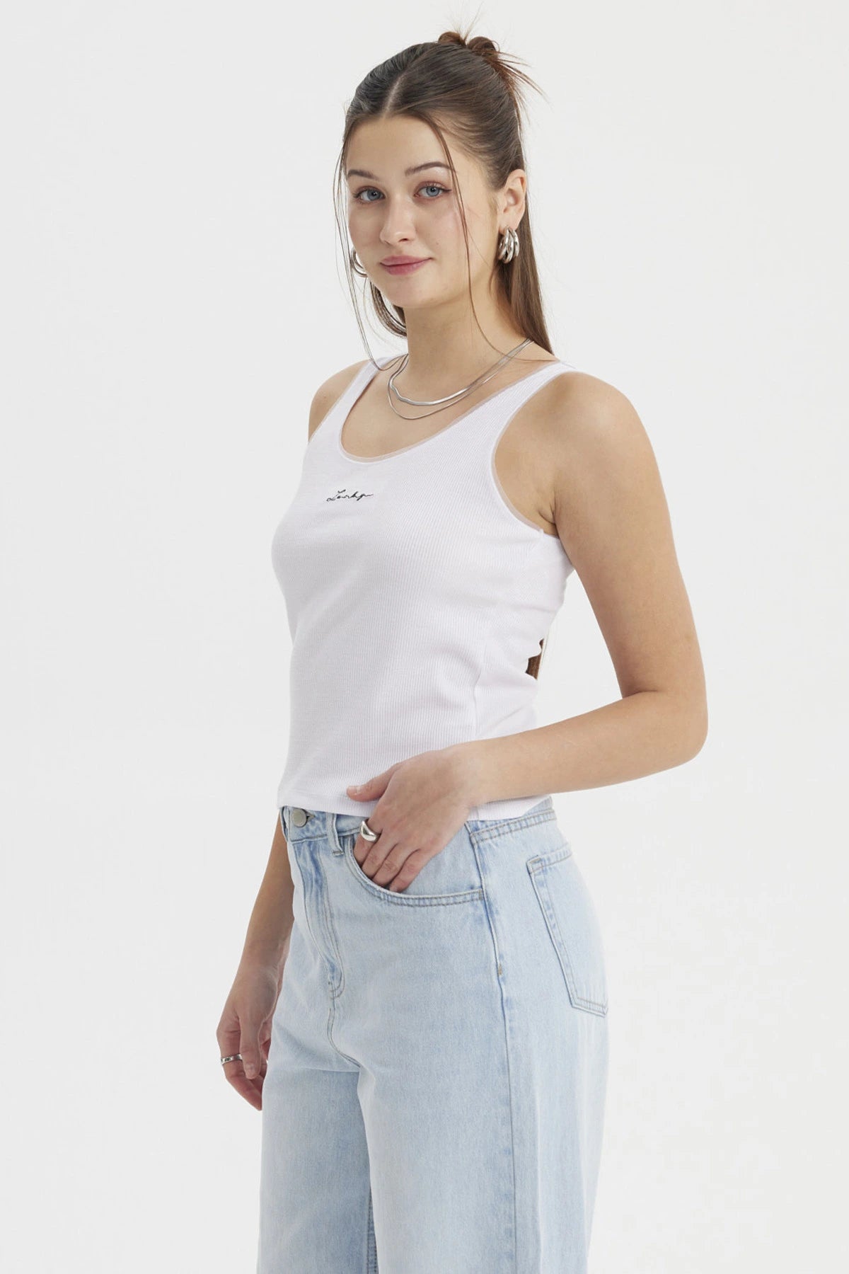 Polera blanca de mujer sin mangas con texto 'Lucky' en el centro de estilo minimalista y corte ajustado