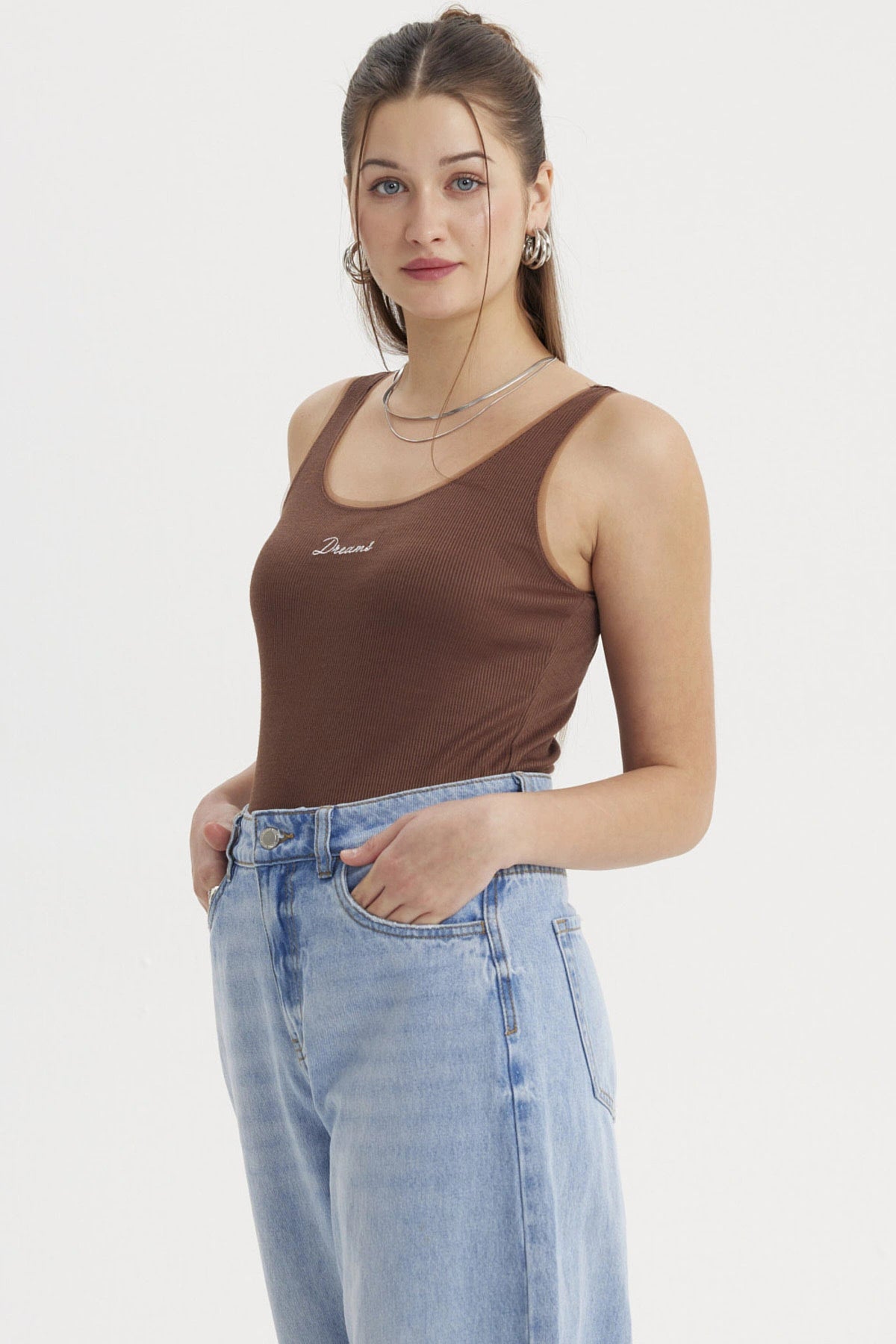 Polera sin mangas café con texto Dreams en el centro estilo minimalista ideal para un look casual y cómodo