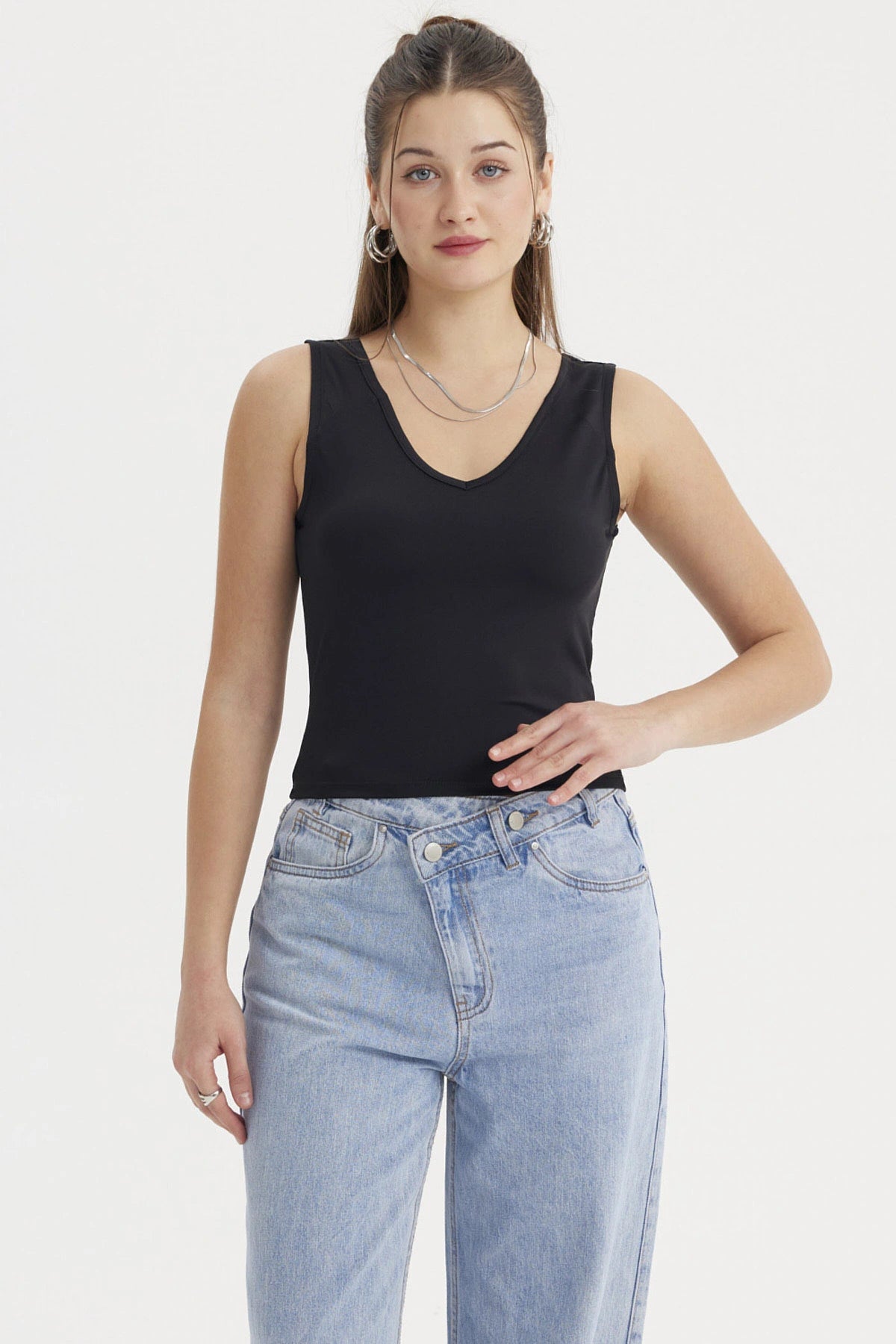 Polera mujer lisa negra sin mangas ajustada al cuerpo perfecta para combinar con jeans en un look casual