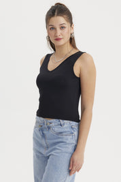 Polera mujer lisa negra sin mangas ajustada al cuerpo perfecta para combinar con jeans en un look casual