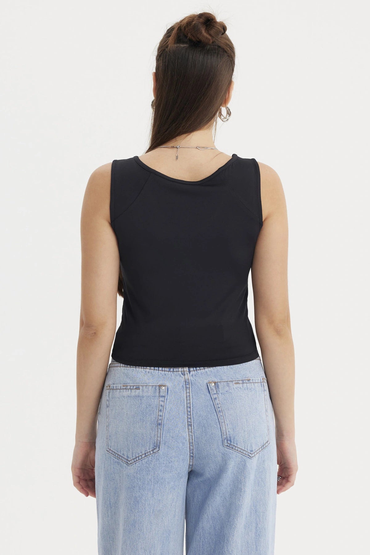 Polera mujer lisa negra sin mangas ajustada al cuerpo perfecta para combinar con jeans en un look casual