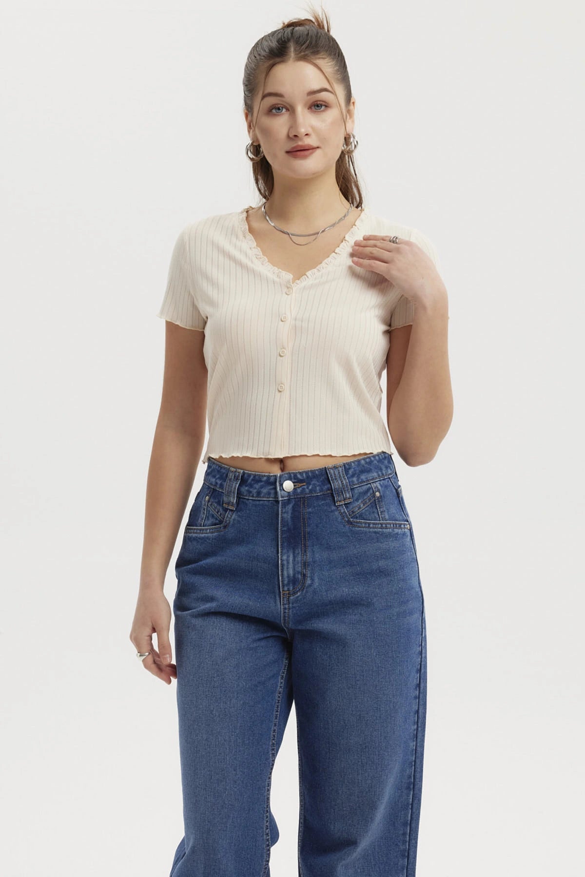 Polera crema de mujer con vuelos en el cuello y botones frontales diseño acanalado lisa elegante y casual