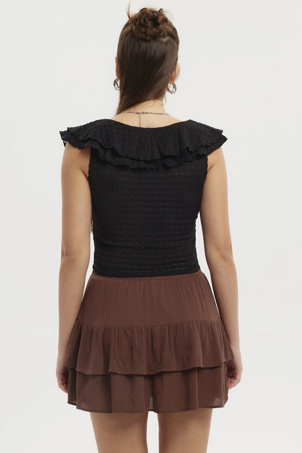 Polera negra sin mangas para mujer con cuello de vuelos y pequeño corte frontal en el pecho prenda lisa elegante