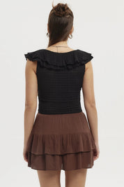 Polera negra sin mangas para mujer con cuello de vuelos y pequeño corte frontal en el pecho prenda lisa elegante