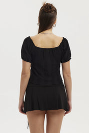 Polera negra de mujer con escote globo y botones al frente sin estampa