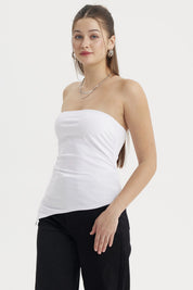 Polera mujer blanca sin mangas con basta asimétrica diseño liso ajustada al cuerpo ideal para un look moderno