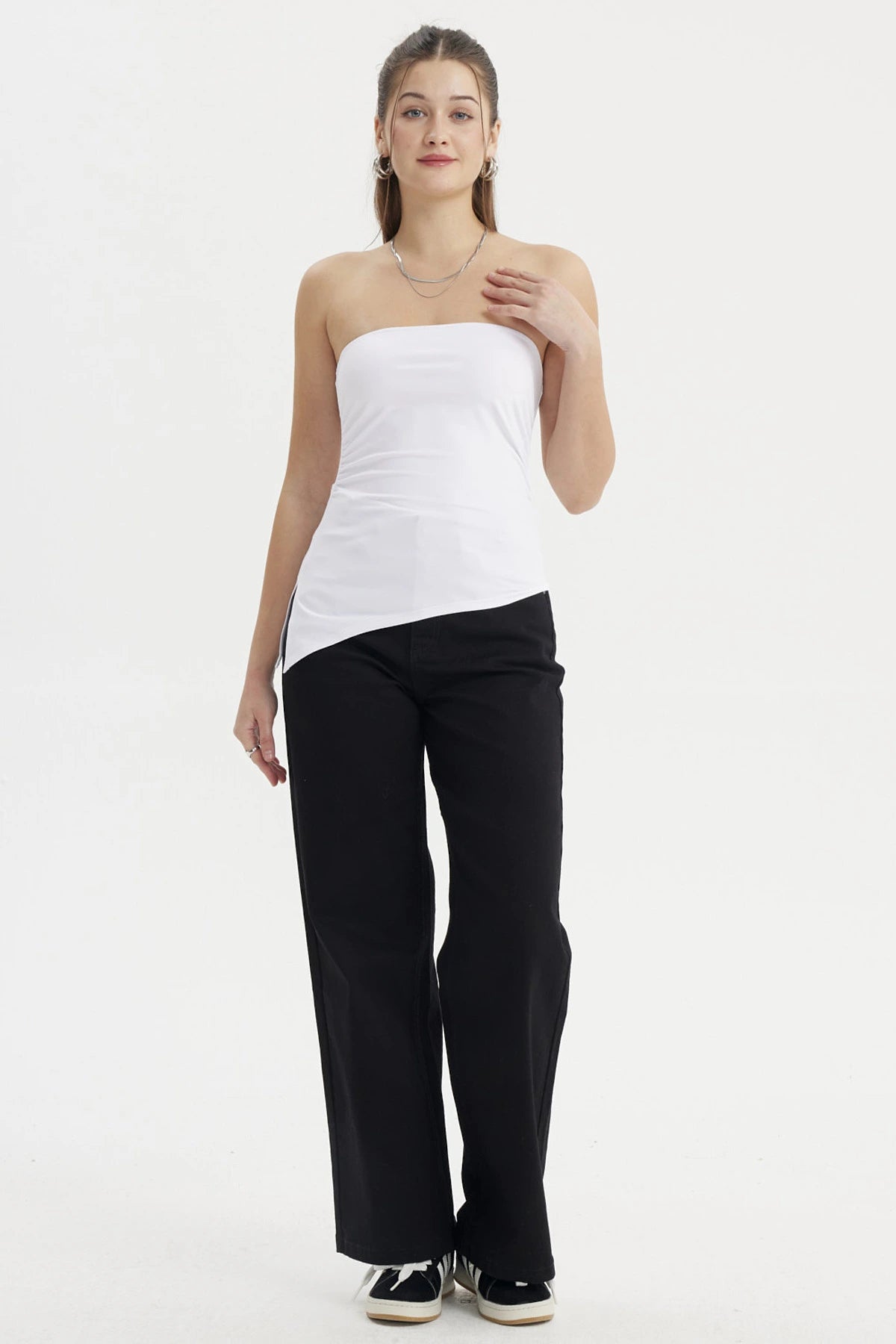 Polera mujer blanca sin mangas con basta asimétrica diseño liso ajustada al cuerpo ideal para un look moderno