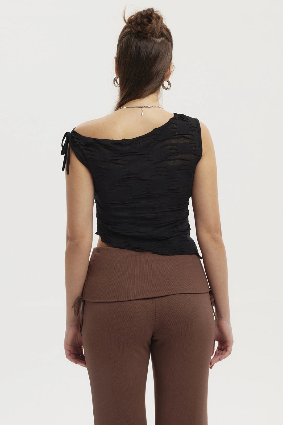 Polera mujer negra con basta asimétrica y textura ondulada sin estampa lisa elegante y moderna