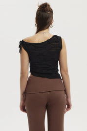 Polera mujer negra con basta asimétrica y textura ondulada sin estampa lisa elegante y moderna
