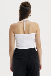 Polera mujer halter blanco sin mangas diseño liso textura arrugada ajustada al cuello con pequeño aro metálico frontal