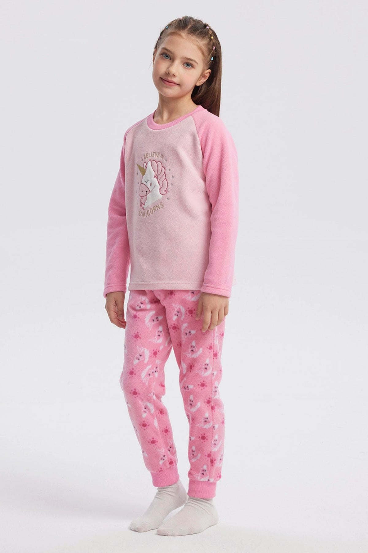 Pijama rosado de niña con polera de unicornio en el centro y pantalón con estampado de unicornios en toda la tela