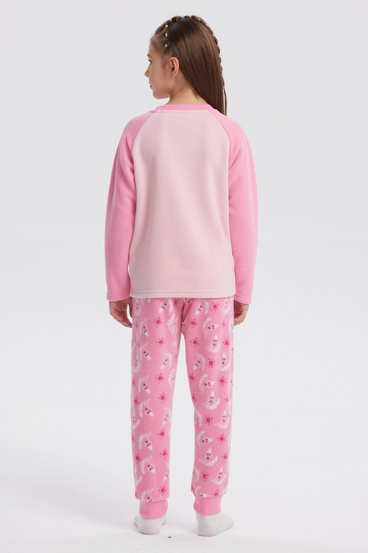Pijama rosado de niña con polera de unicornio en el centro y pantalón con estampado de unicornios en toda la tela