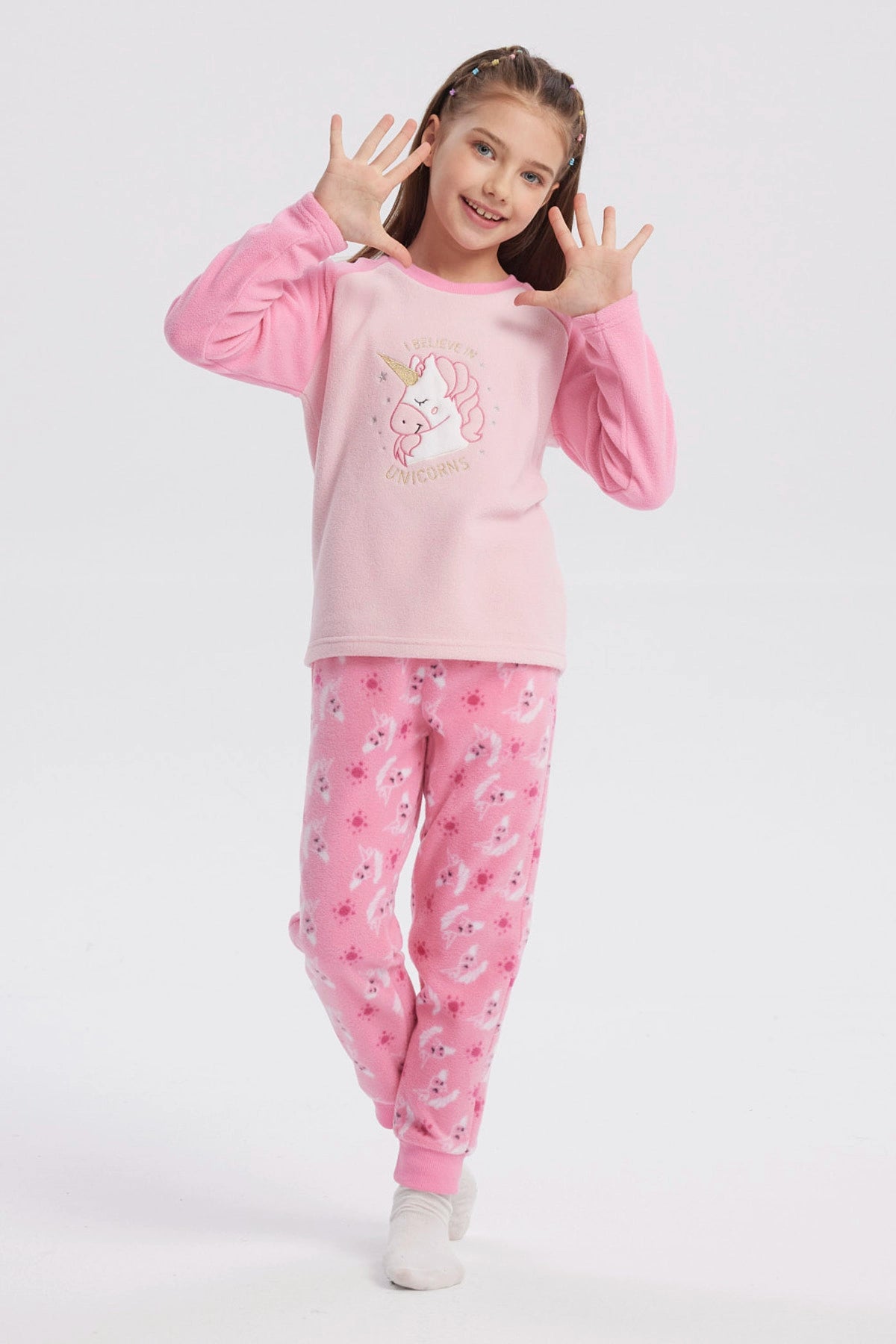 Pijama rosado de niña con polera de unicornio en el centro y pantalón con estampado de unicornios en toda la tela