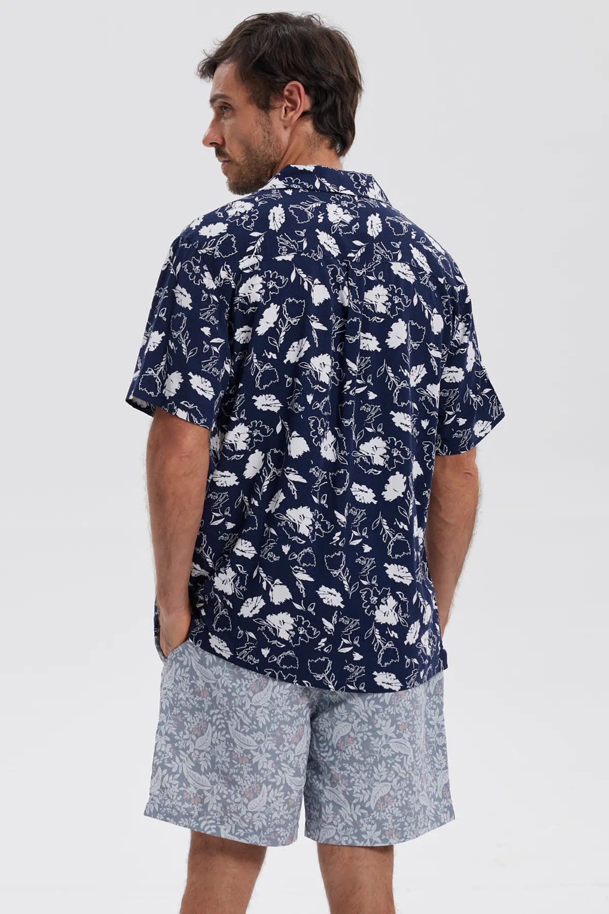 Camisa azul marino de hombre con estampado floral blanco en toda la prenda estilo casual relajado