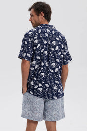 Camisa azul marino de hombre con estampado floral blanco en toda la prenda estilo casual relajado