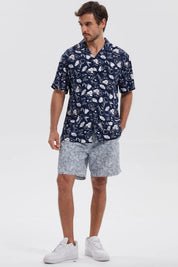 Camisa azul marino de hombre con estampado floral blanco en toda la prenda estilo casual relajado