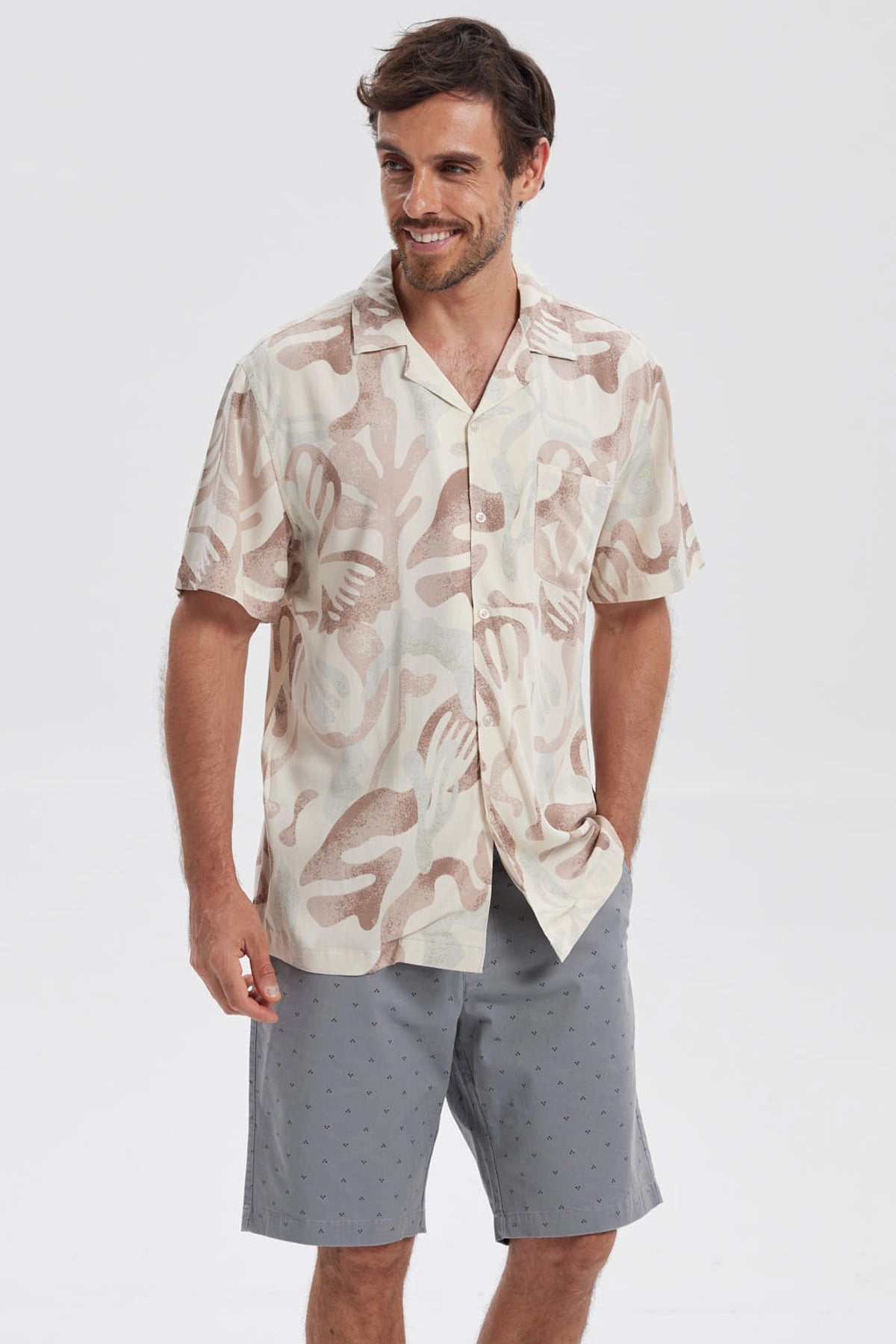 Camisa de hombre blanca con estampado abstracto en tonos marrones y beige manga corta sin bolsillo visible diseño casual