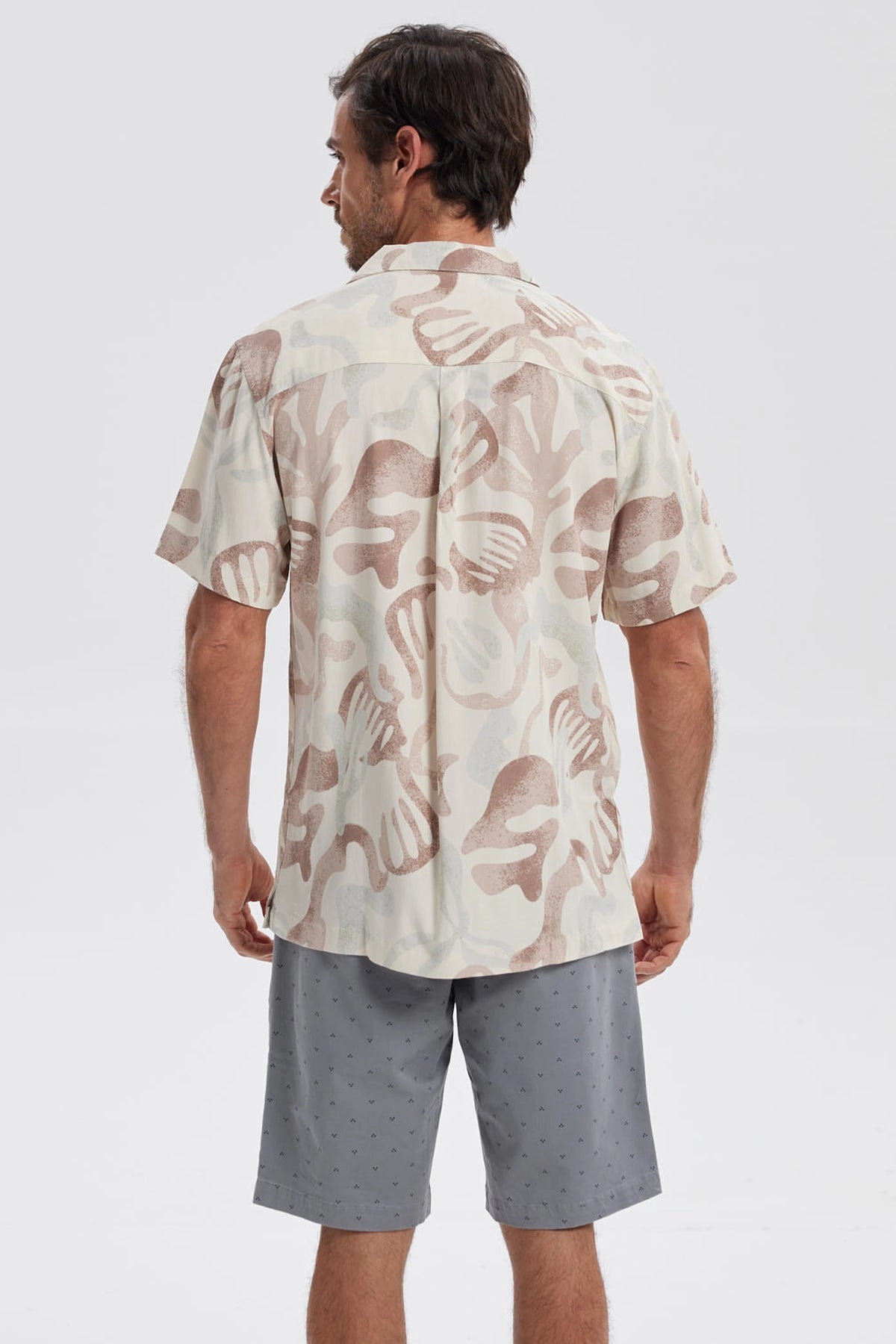 Camisa de hombre blanca con estampado abstracto en tonos marrones y beige manga corta sin bolsillo visible diseño casual