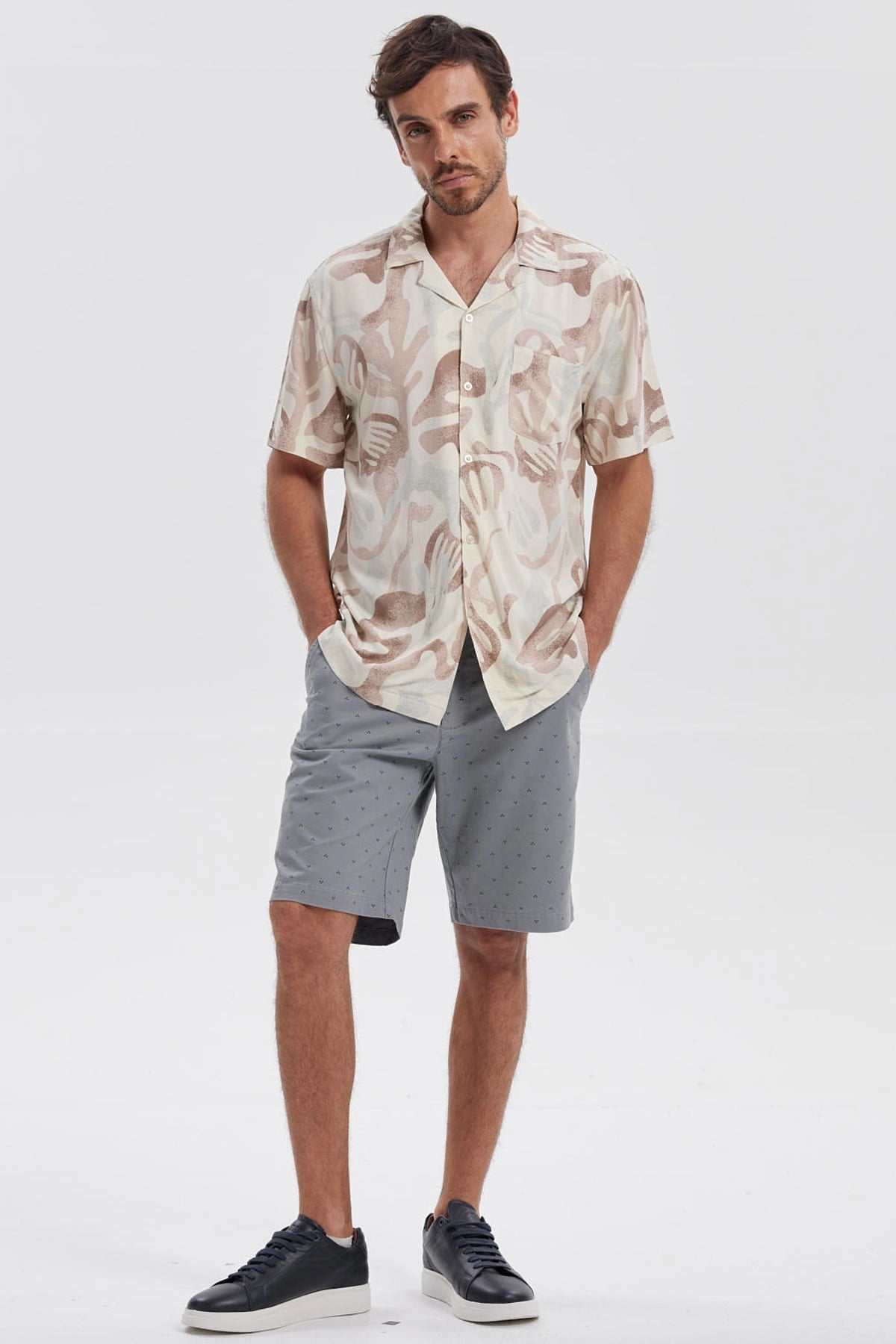 Camisa de hombre blanca con estampado abstracto en tonos marrones y beige manga corta sin bolsillo visible diseño casual
