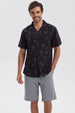 Camisa negra de hombre con estampado de hojas y piñas en gris de estilo tropical por toda la prenda