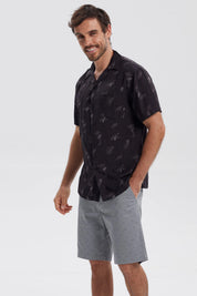 Camisa negra de hombre con estampado de hojas y piñas en gris de estilo tropical por toda la prenda