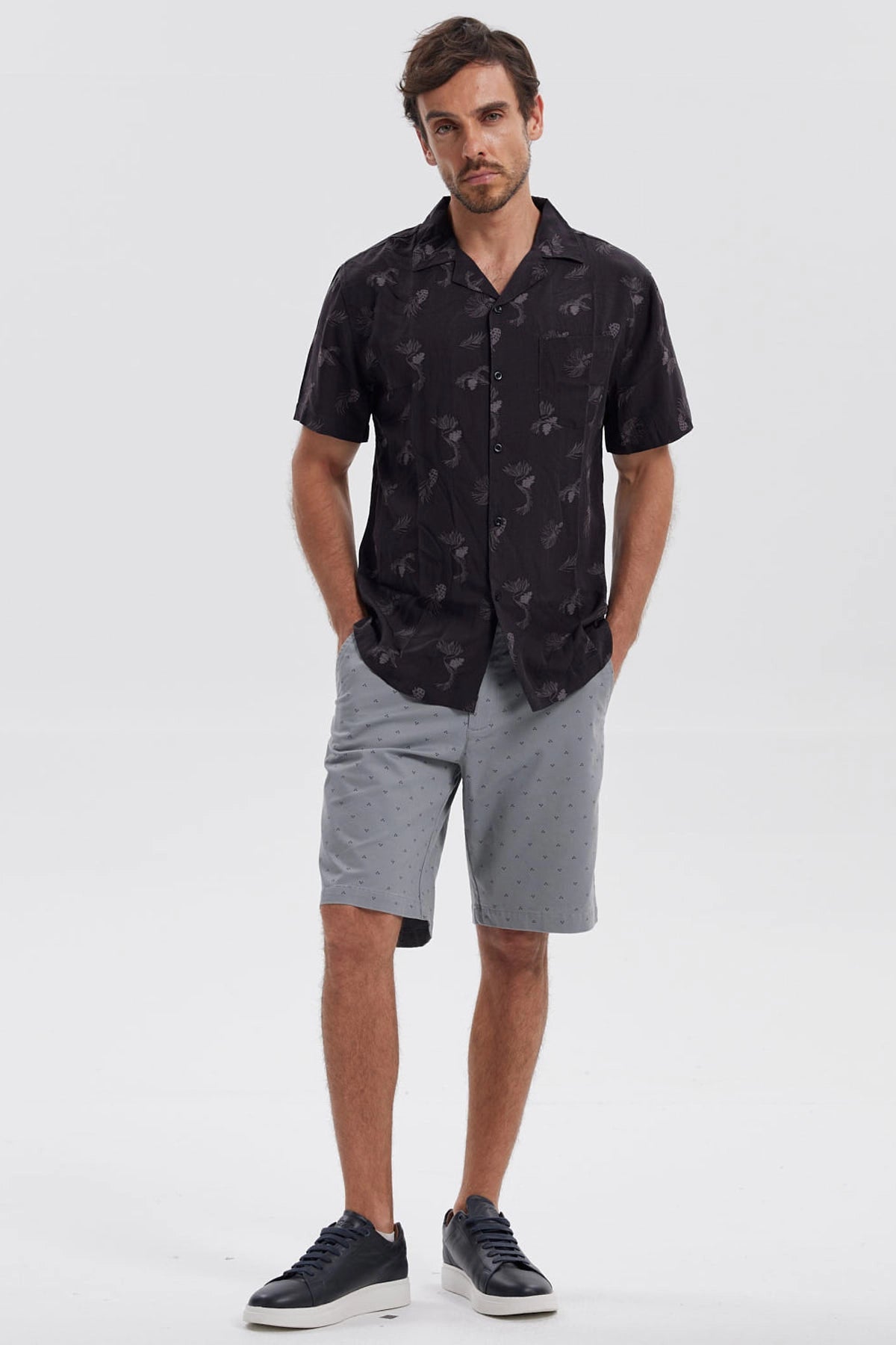 Camisa negra de hombre con estampado de hojas y piñas en gris de estilo tropical por toda la prenda