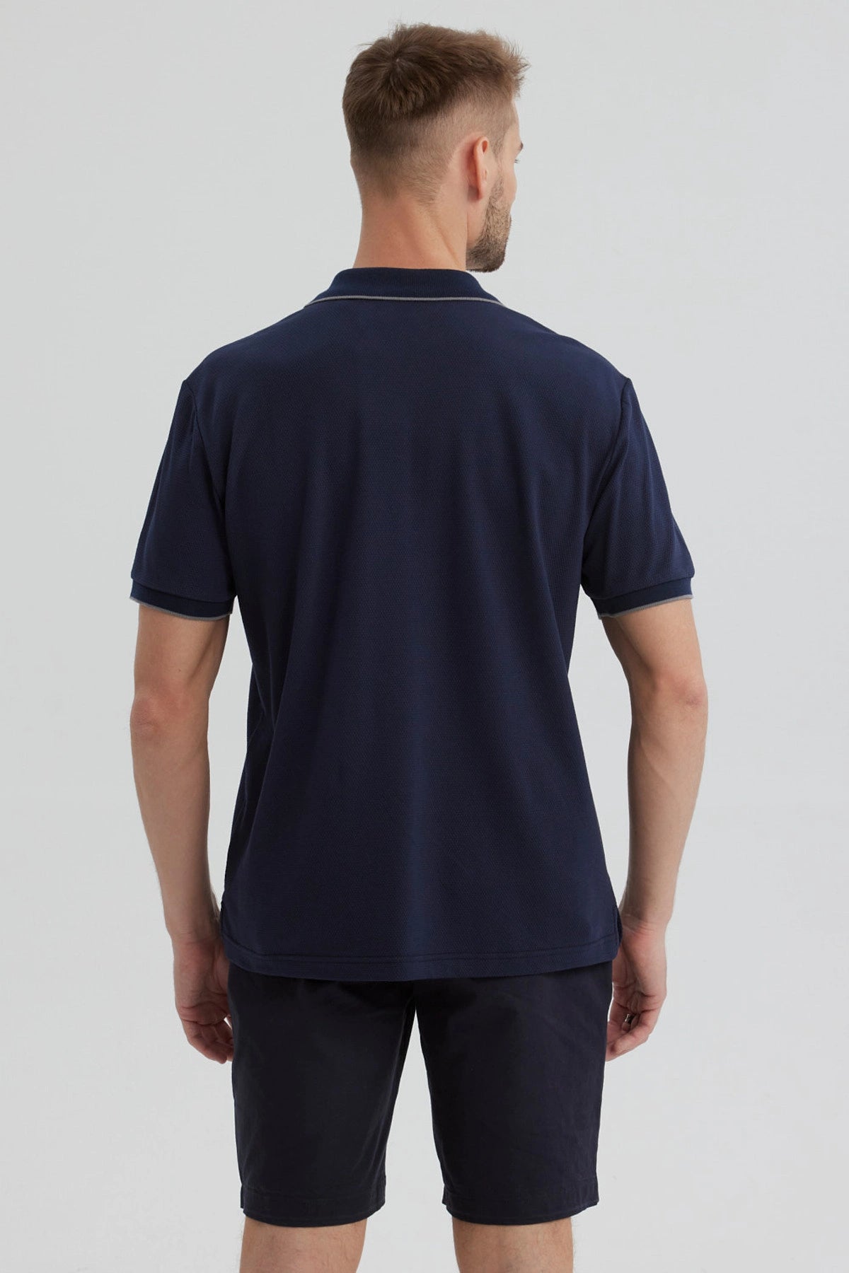Polera hombre azul marino con cierre frontal corto y detalle discreto en el pecho diseño liso sin estampa visible