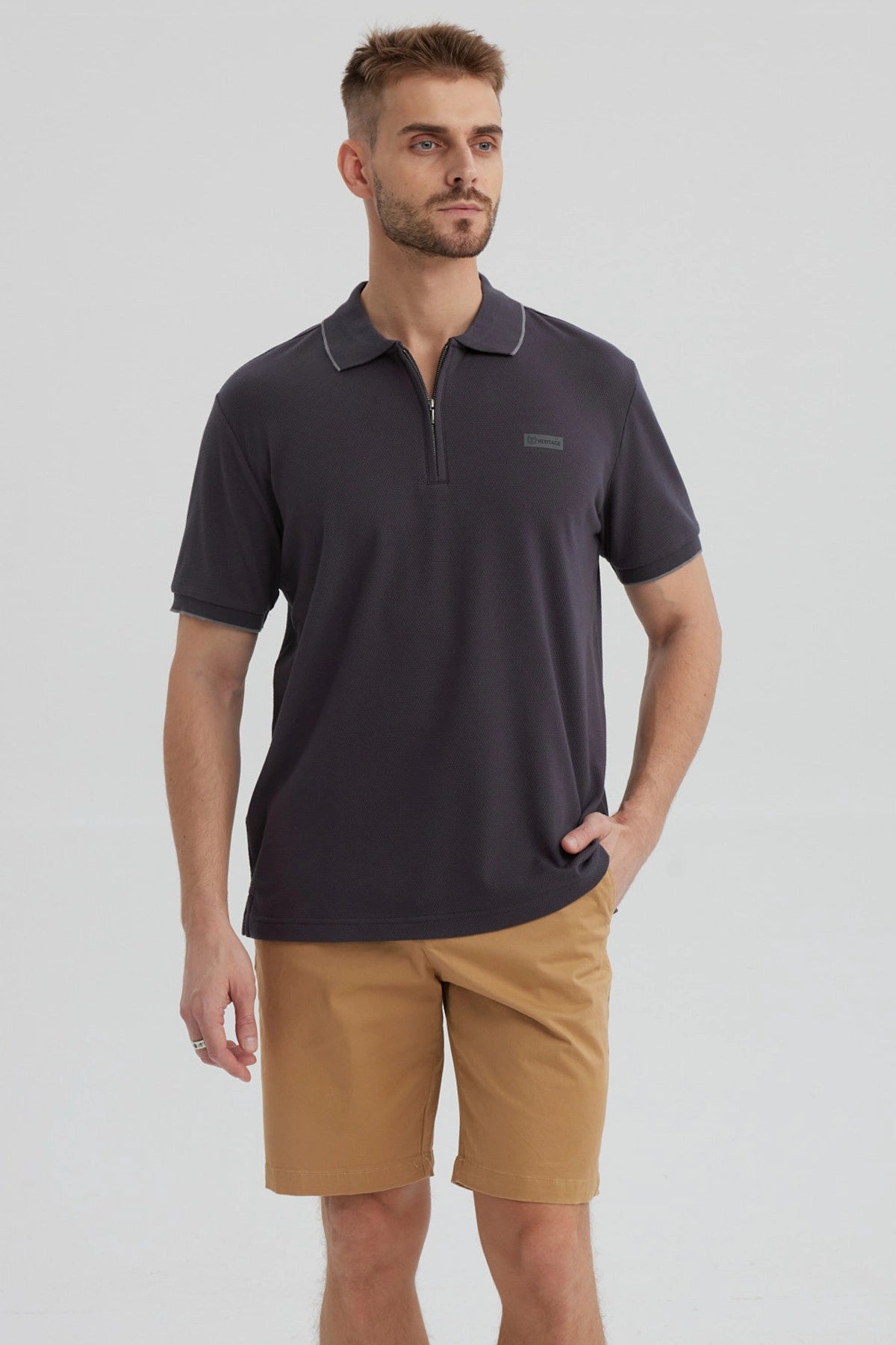 Polera hombre gris con cierre frontal y logo discreto en el pecho estilo casual para un look relajado y moderno