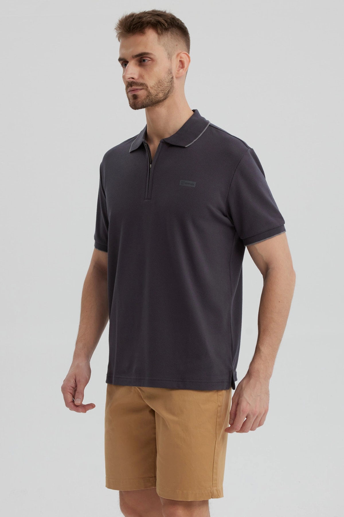 Polera hombre gris con cierre frontal y logo discreto en el pecho estilo casual para un look relajado y moderno
