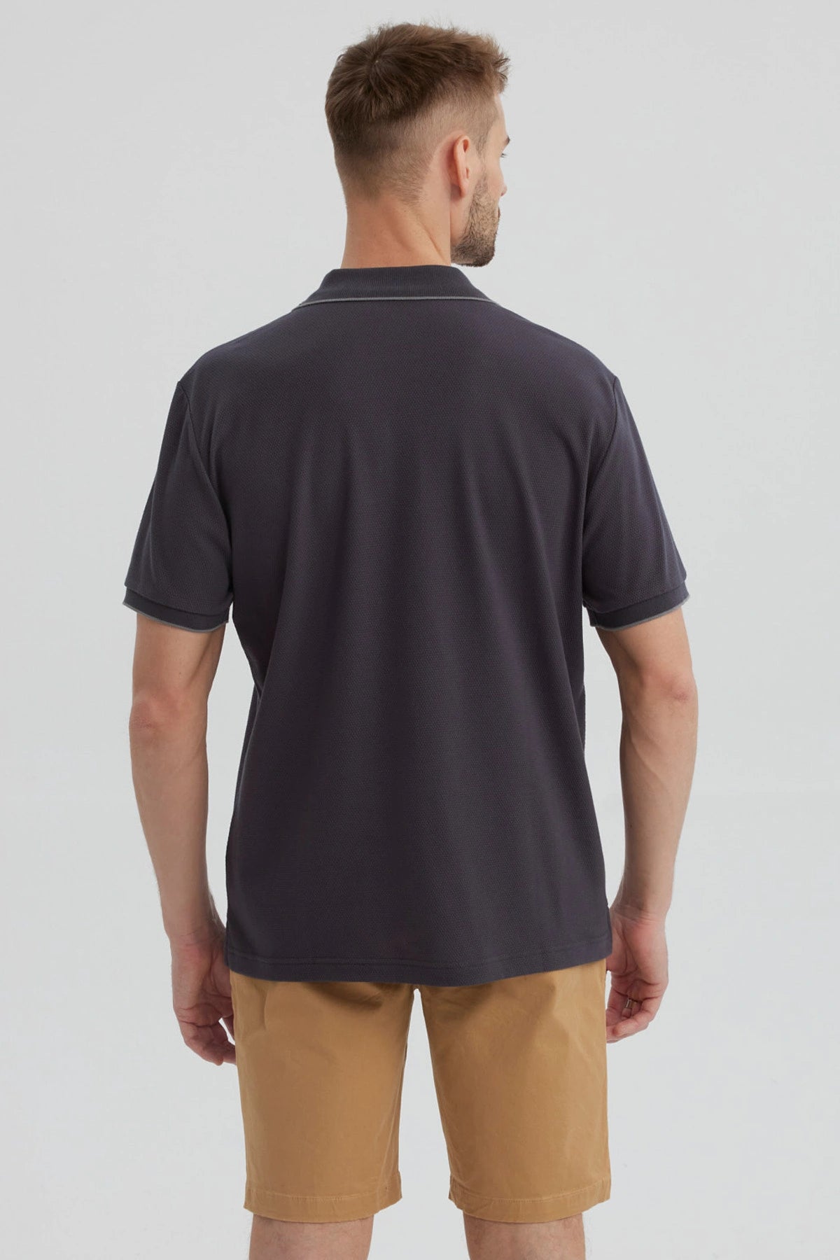 Polera hombre gris con cierre frontal y logo discreto en el pecho estilo casual para un look relajado y moderno