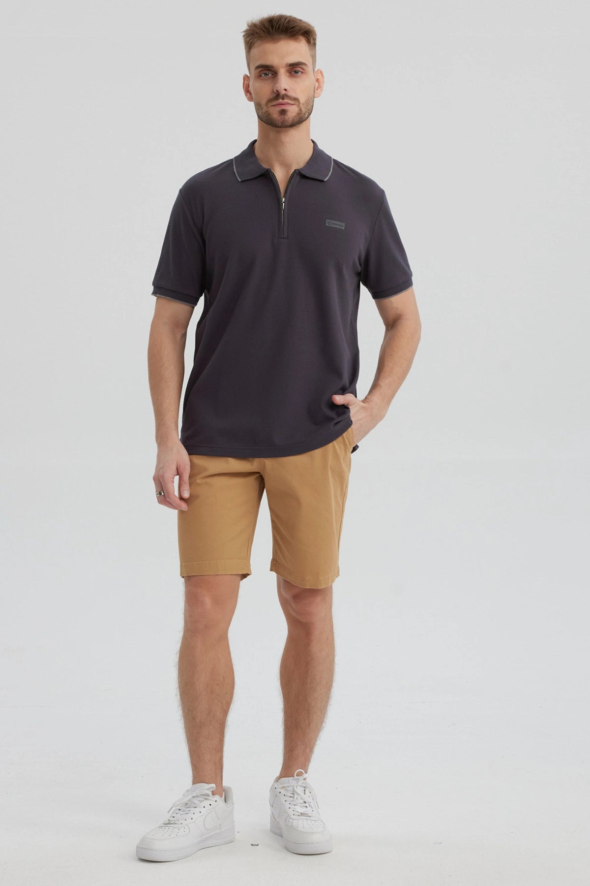 Polera hombre gris con cierre frontal y logo discreto en el pecho estilo casual para un look relajado y moderno