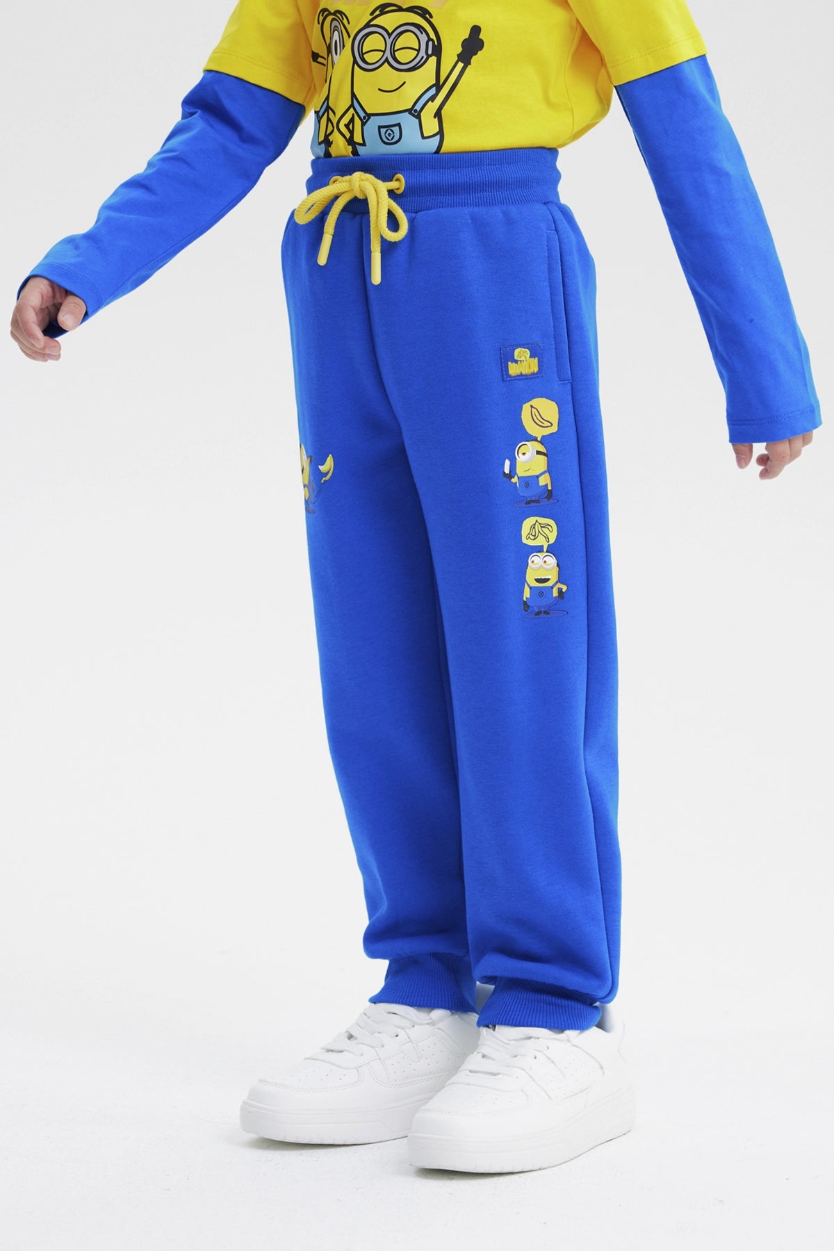 Pantalón de buzo azul para niño con estampa de Minions pequeños en la pierna izquierda estilo animado