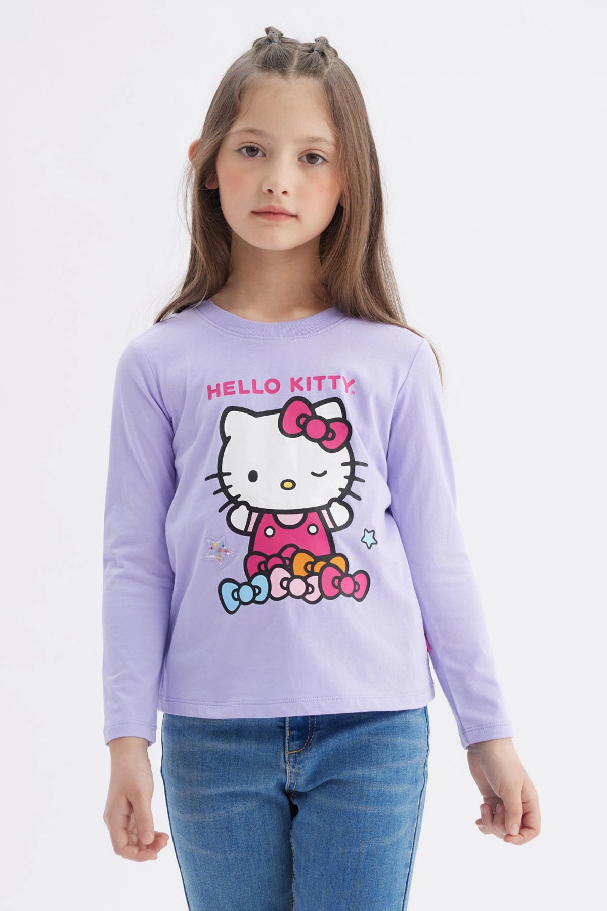 Polera niña lila con Hello Kitty en el frente con moños de colores y texto Hello Kitty en estilo gráfico animado