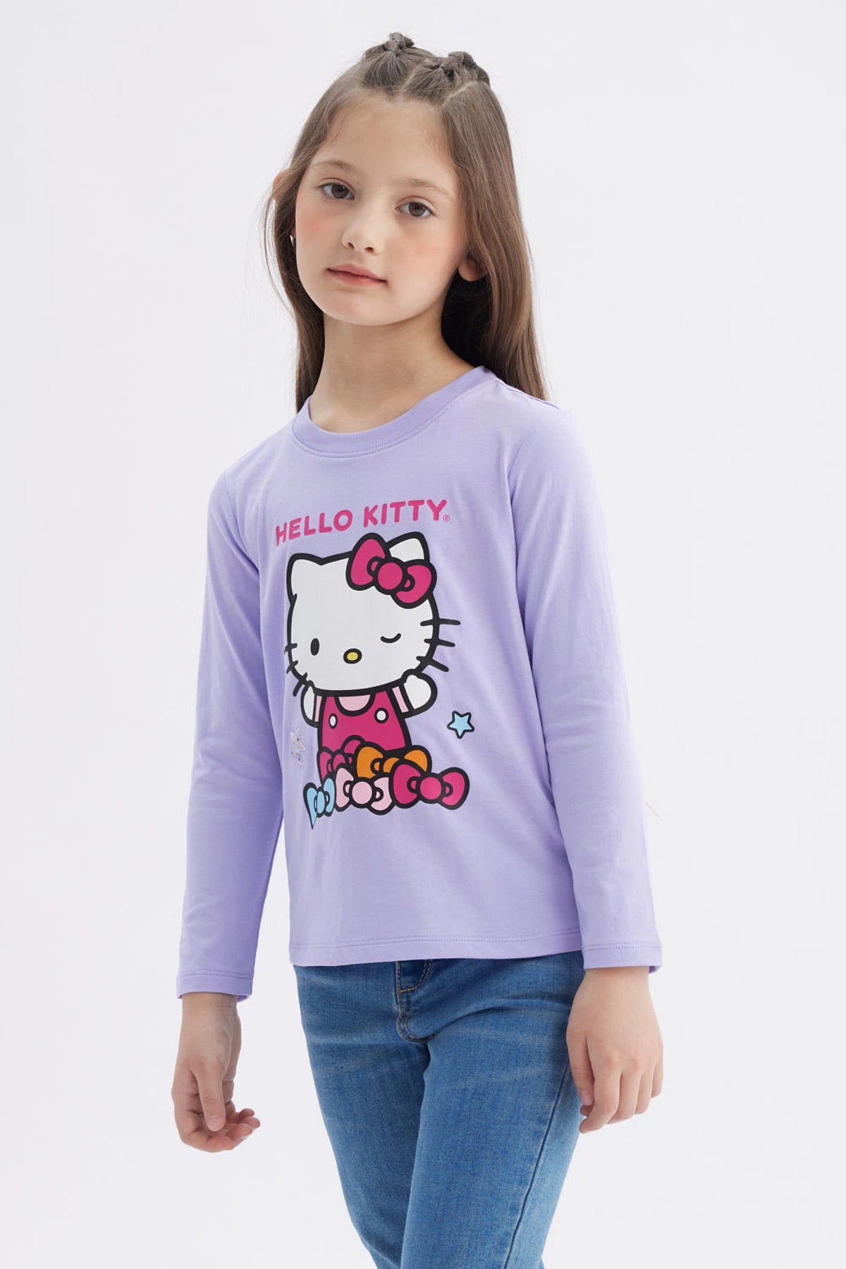 Polera niña lila con Hello Kitty en el frente con moños de colores y texto Hello Kitty en estilo gráfico animado