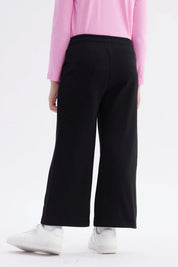 Pantalón buzo negro niña con estampado rosa de Hello Kitty en pierna izquierda estilo gráfico grande y texto Hello Kitty