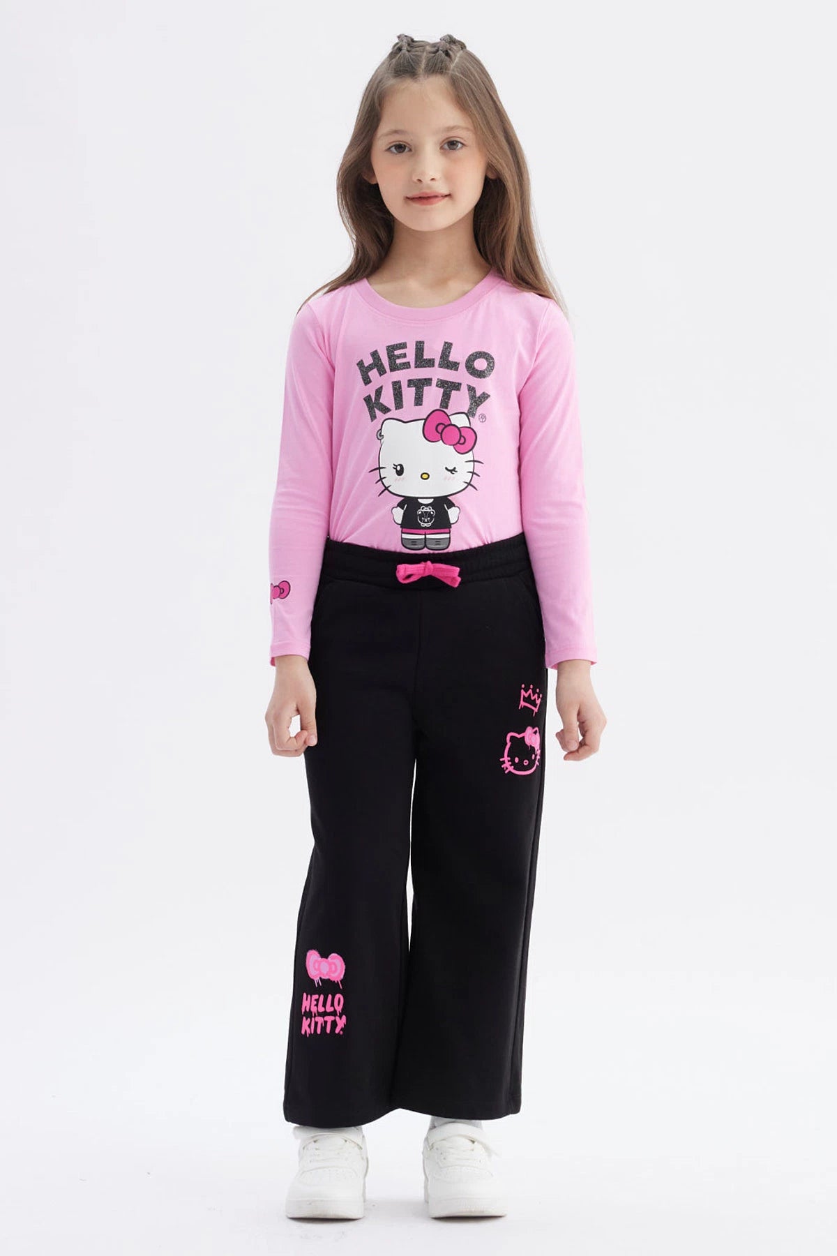 Pantalón buzo negro niña con estampado rosa de Hello Kitty en pierna izquierda estilo gráfico grande y texto Hello Kitty