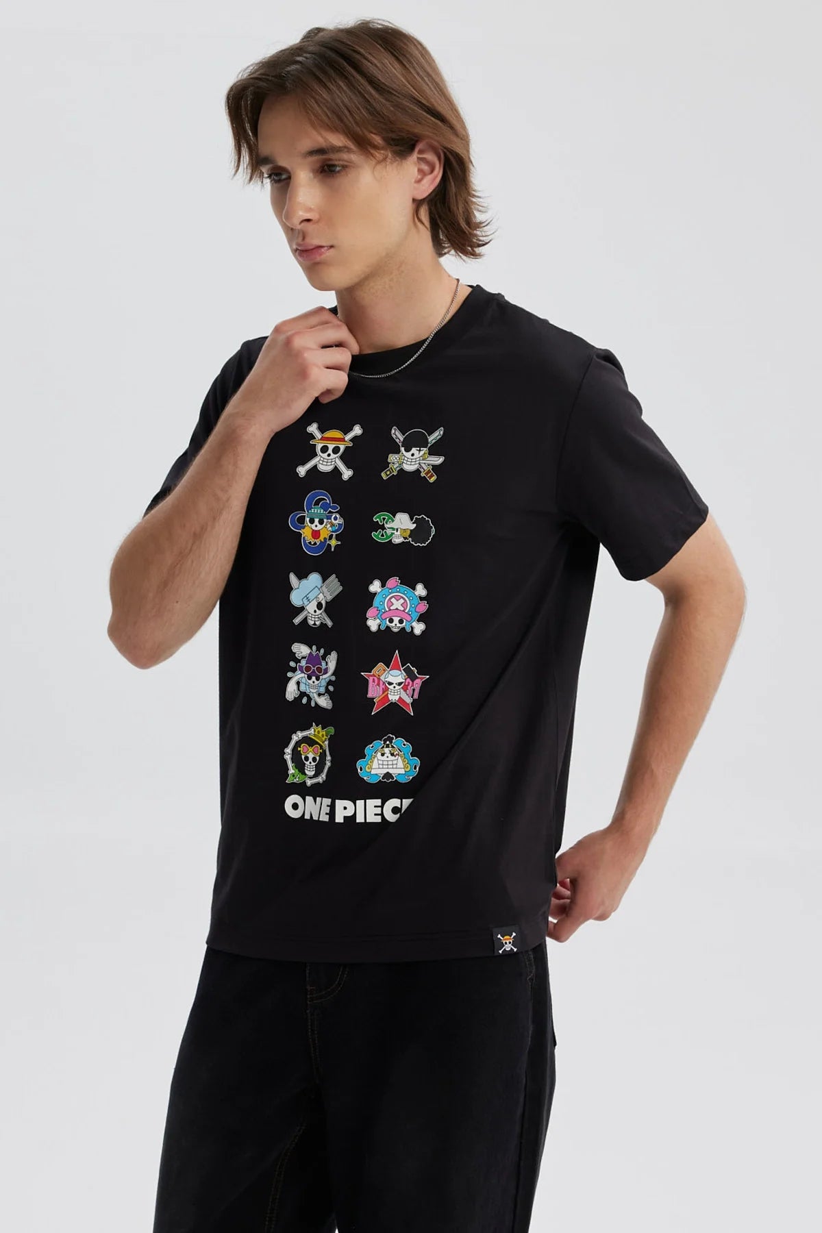 Polera negra de hombre con estampado de One Piece y varios símbolos en el frente
