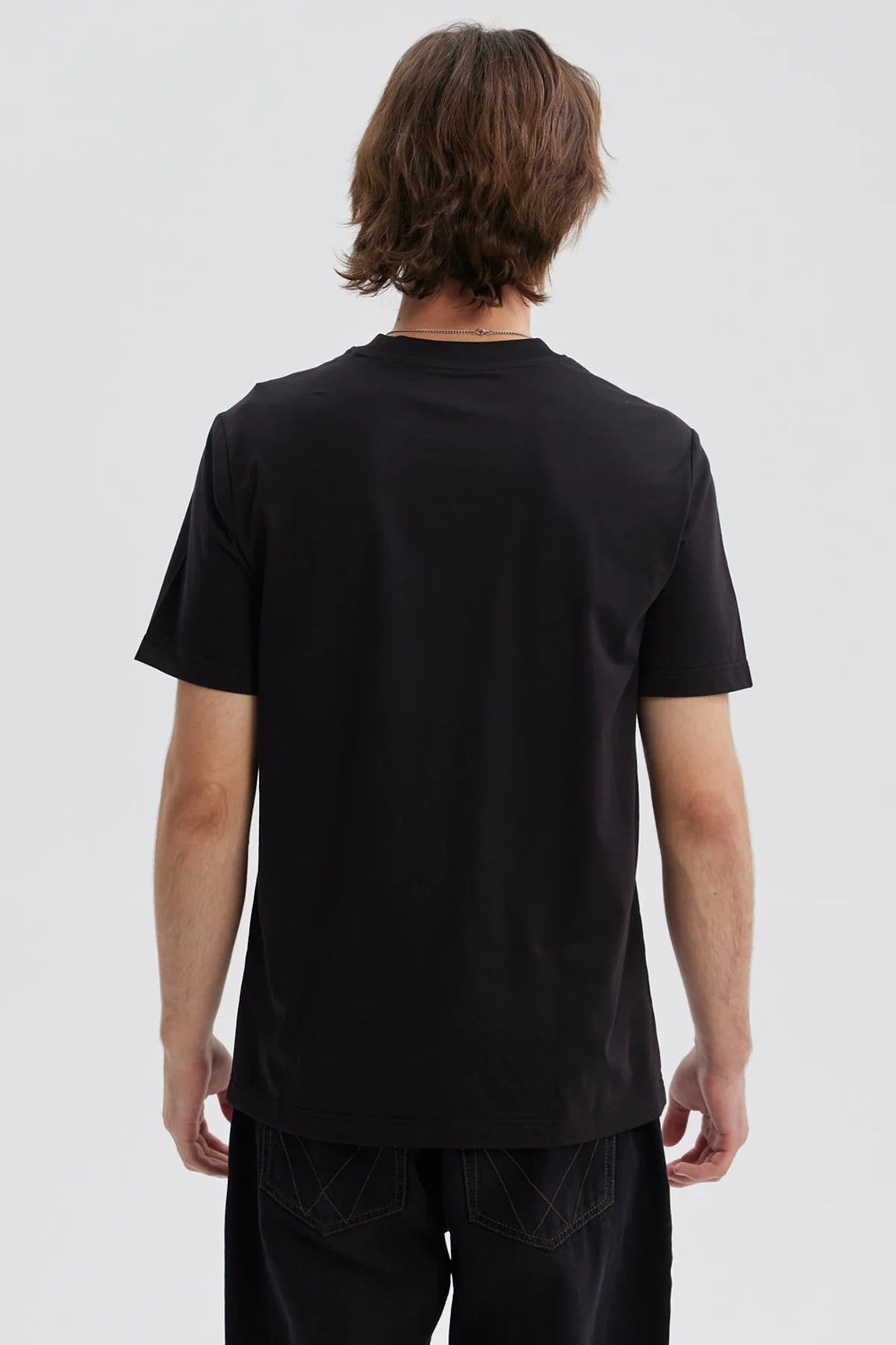 Polera negra de hombre con estampado de One Piece y varios símbolos en el frente