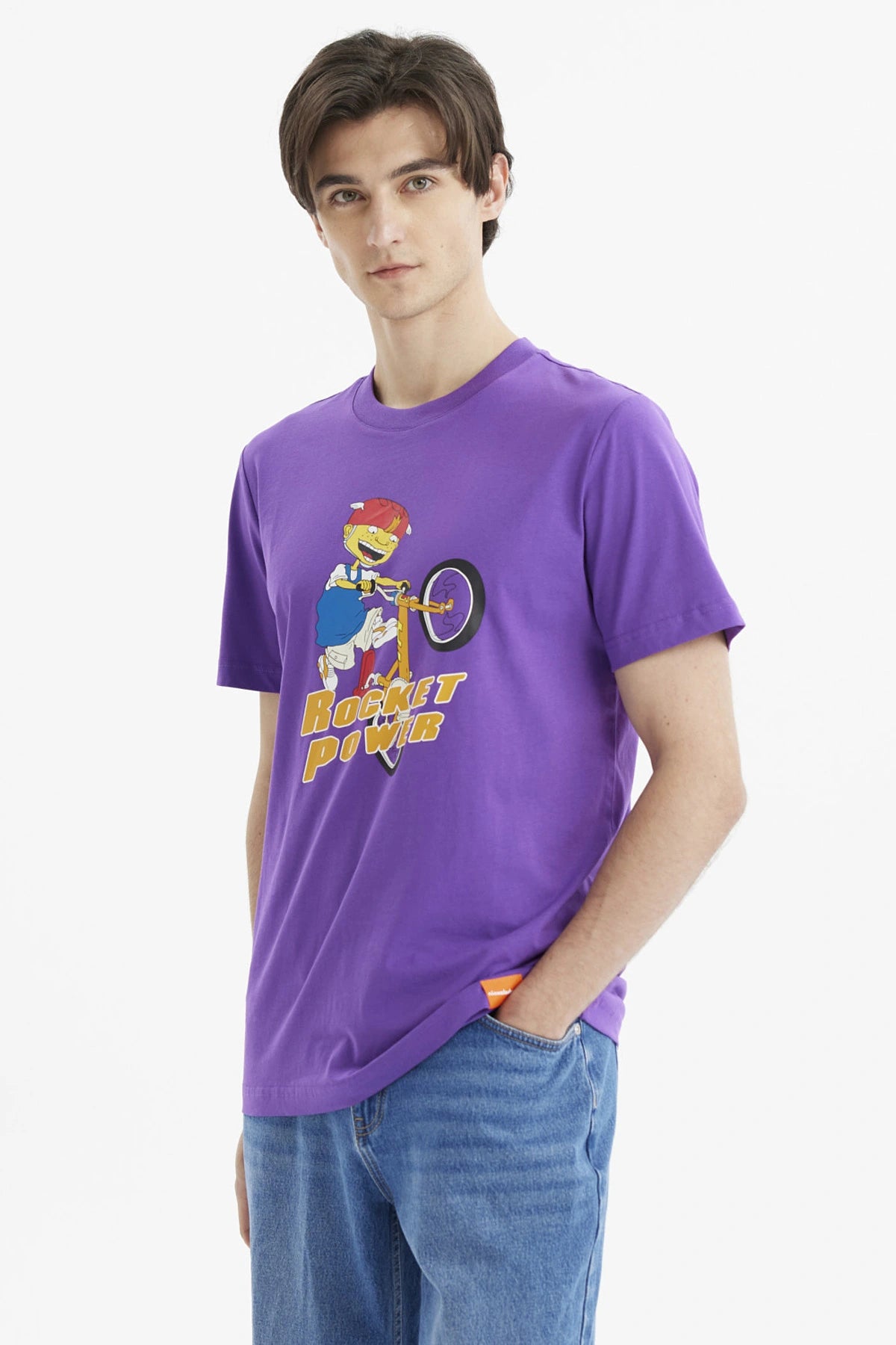 Polera morada de hombre con personaje animado en bicicleta y texto Rocket Power al frente estilo caricatura