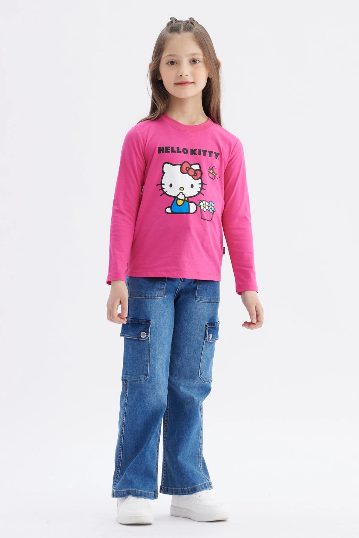Polera niña rosada de manga larga con Hello Kitty grande al centro sosteniendo una regadera junto a flores