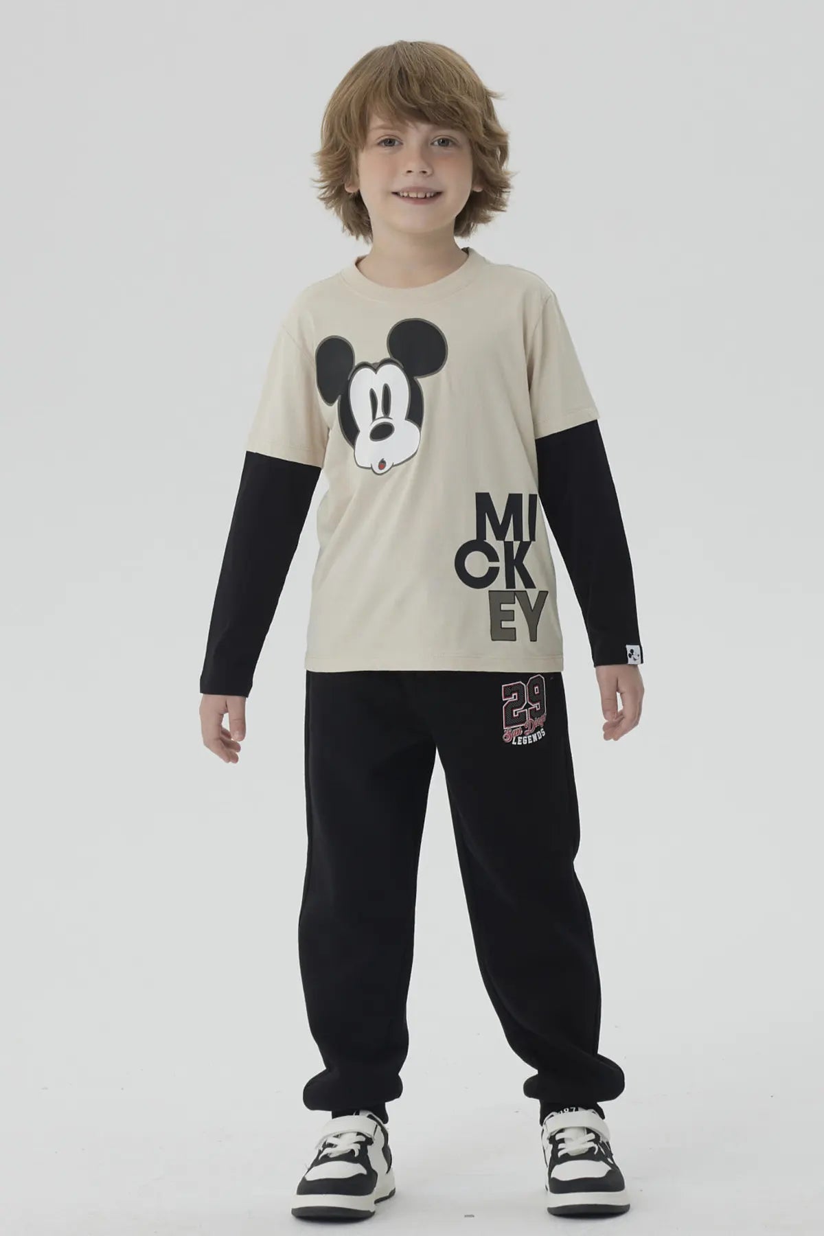 Polera de niño caqui con imagen de Mickey Mouse en el centro y texto MICKEY abajo en letras grandes negras